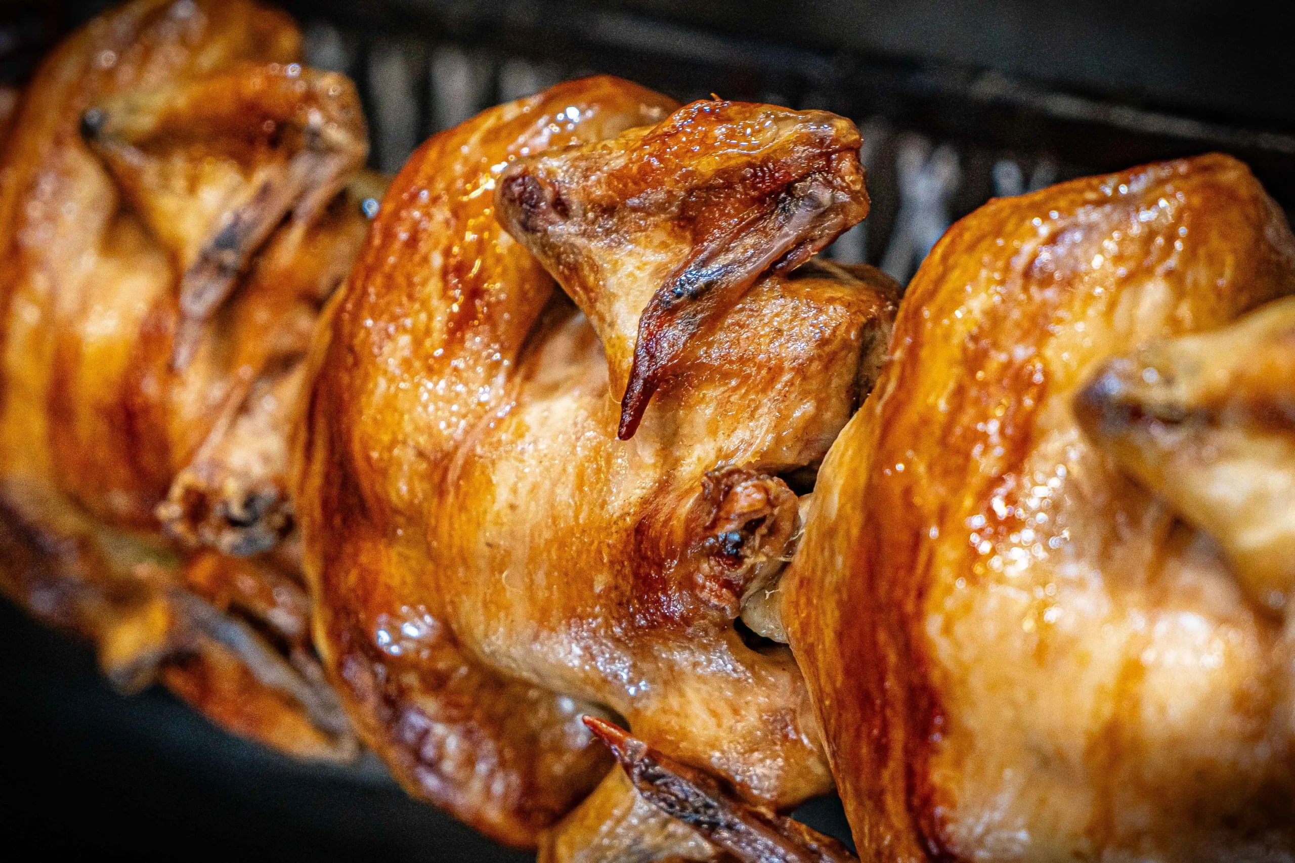 A variety of dishes made from leftover rotisserie chicken, including wraps, pasta, soup, quesadillas, and stuffed potatoes, displayed on a rustic table.