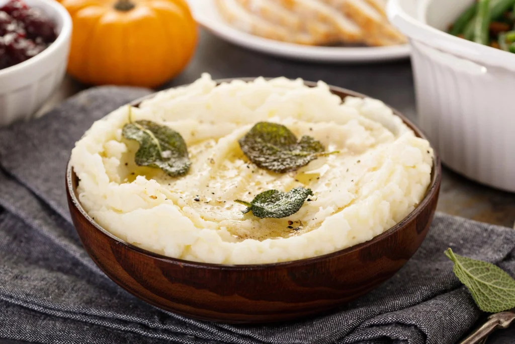 A variety of soft food dishes including mashed potatoes, creamy vegetable soup, scrambled eggs, and a protein smoothie bowl served on a table.