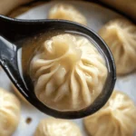 Close-up of vegan soup dumplings served in a bamboo steamer, showcasing their delicate folds and tender, translucent wrappers
